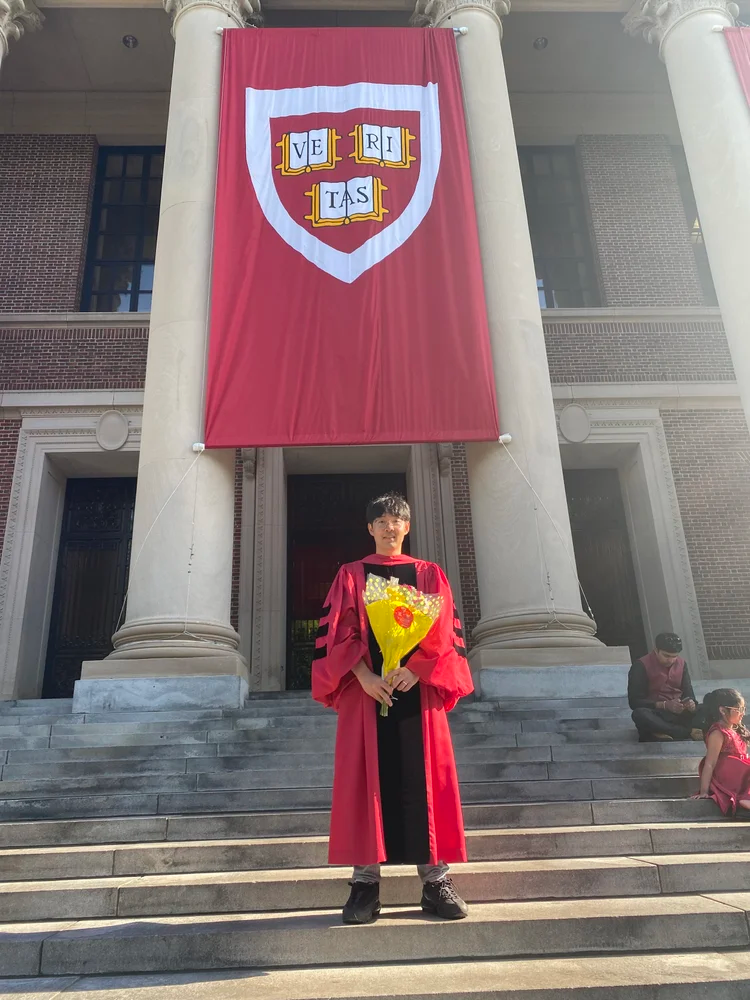 Jongsik Christian Yi portrait in front of a Harvard shield
